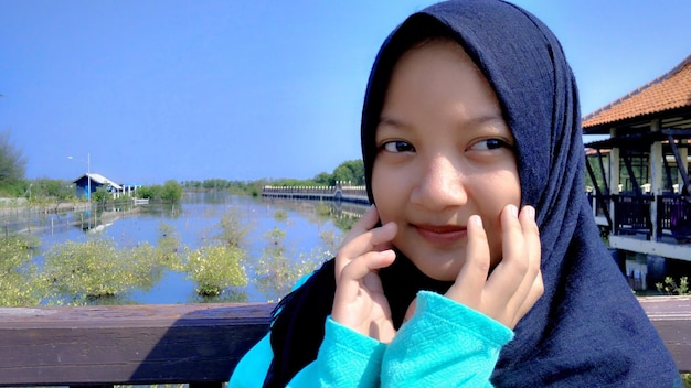 Photo smiling young woman standing on footbridge