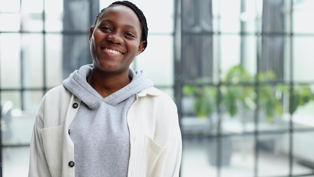 Smiling young woman standing and looking at the camera