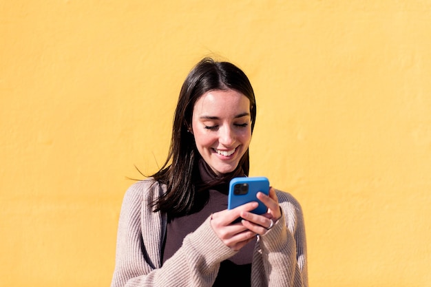 Smiling young woman using mobile phone