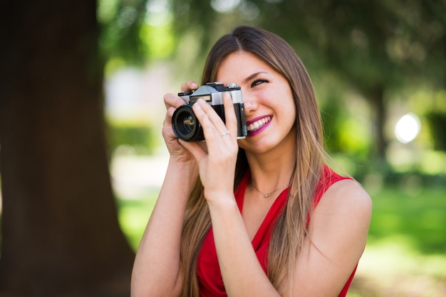 Smiling young woman using a vintage camera