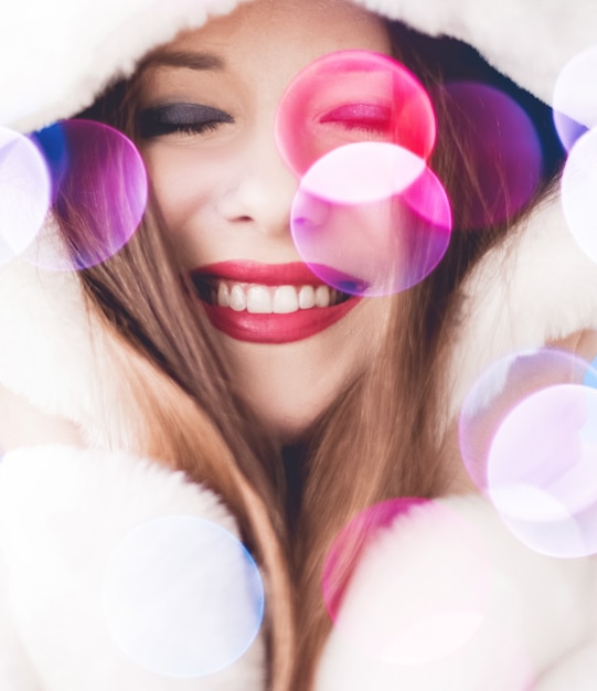 Smiling young woman wearing fluffy white fur coat