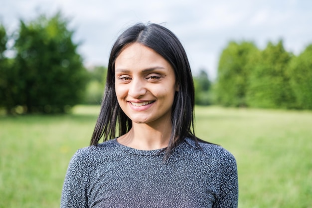 Smiling young woman with black hair having a fun time outdoors