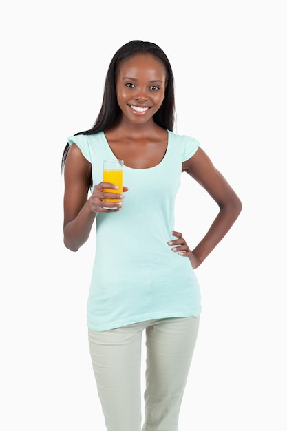 Smiling young woman with a glass of orange juice