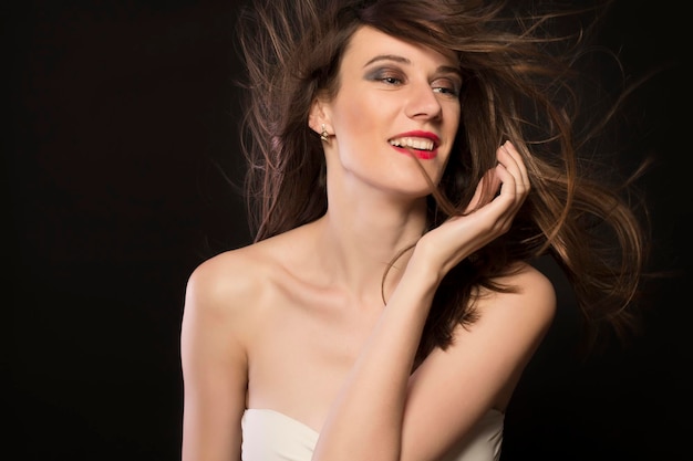 Smiling young woman with hair motion closeup