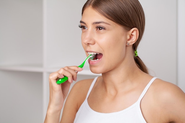 Smiling young woman with healthy teeth holding a tooth brush