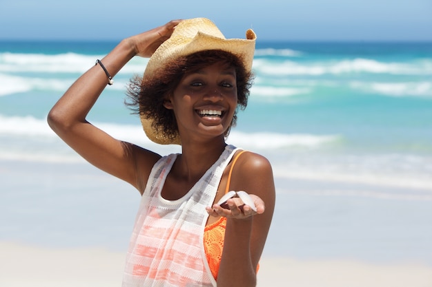 Smiling young woman with seashell at the beach