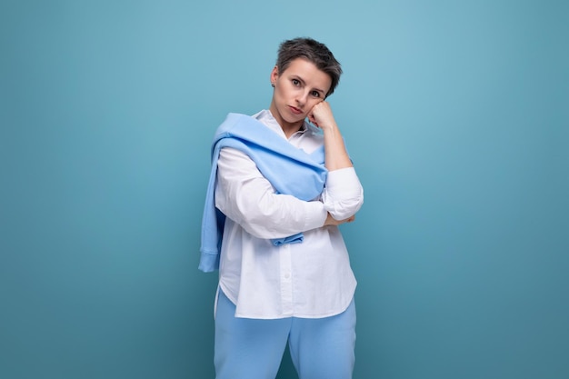 Smiling young woman with short haircut in white shirt and blue pants