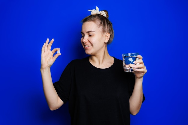 Smiling young woman without makeup in black tshirt drinking vitamins for health mature woman natural beauty concept Morning glass of water immune care vitamin complex for women Selective focus