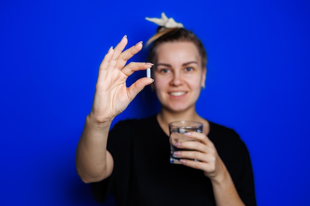 Smiling young woman without makeup in black tshirt drinking vitamins for health mature woman natural beauty concept Morning glass of water immune care vitamin complex for women Selective focus