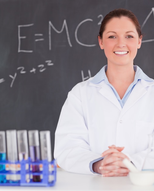 Photo smilling scientist stanting in front of a blackboard