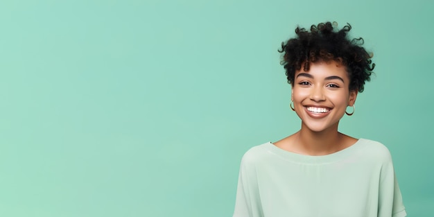 Smimilg young woman with dark skin and short groomed hair isolated on flat green pastel background with copy space Model for banner of cosmetic products beauty salon and dentistry