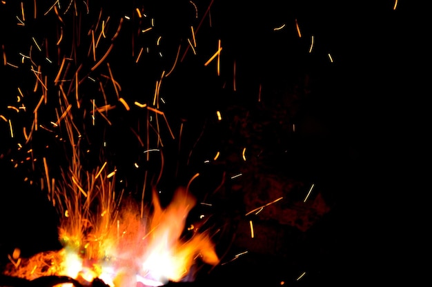 Smithy fire flame tips with sparks closeup on dark background