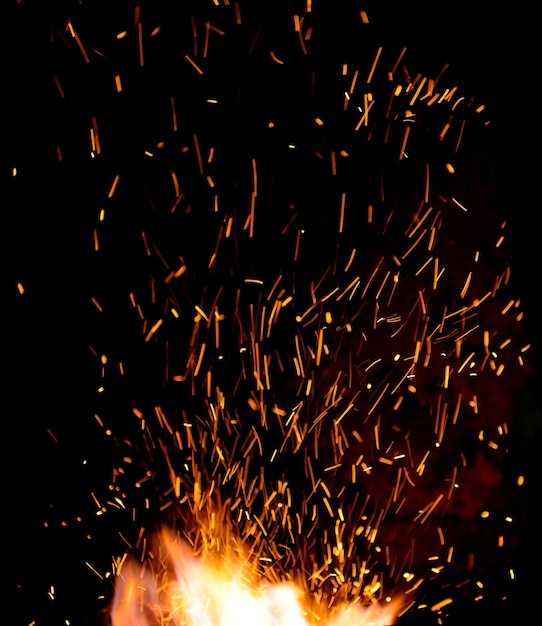 Smithy fire flame tips with sparks closeup on dark background