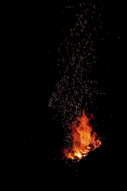 Smithy fire flame tips with sparks closeup on dark background