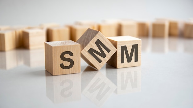 SMM - Social Media Marketing acronym concept on cubes, gray background