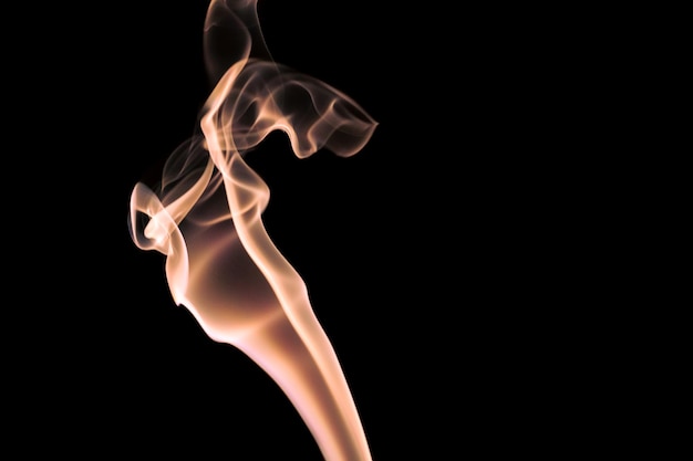 A smoke against a black background is lit up by a black background.