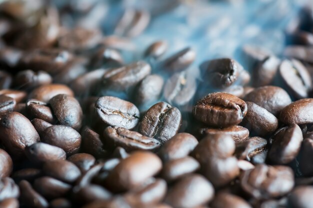 Photo smoke comes from roasted fragrant coffee beans aroma, on frying pan