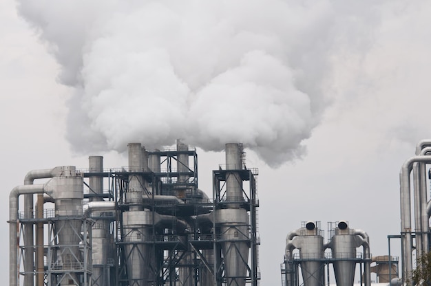 Smoke emitting from factory against sky