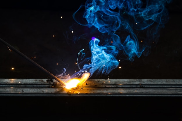 Smoke and flame of welding work on dark background 