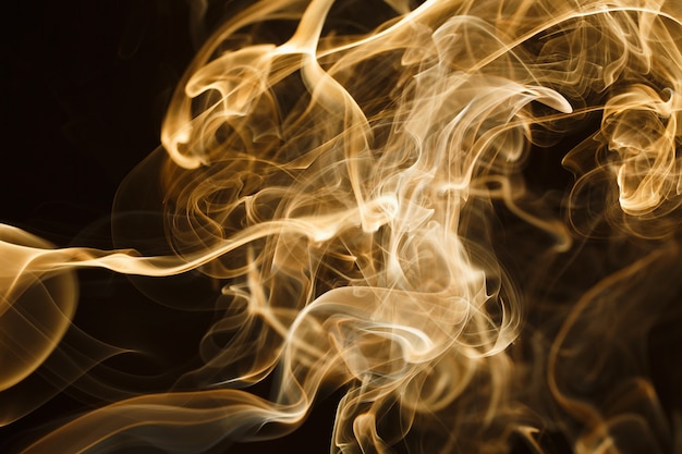 Smoke floating in the air on dark background