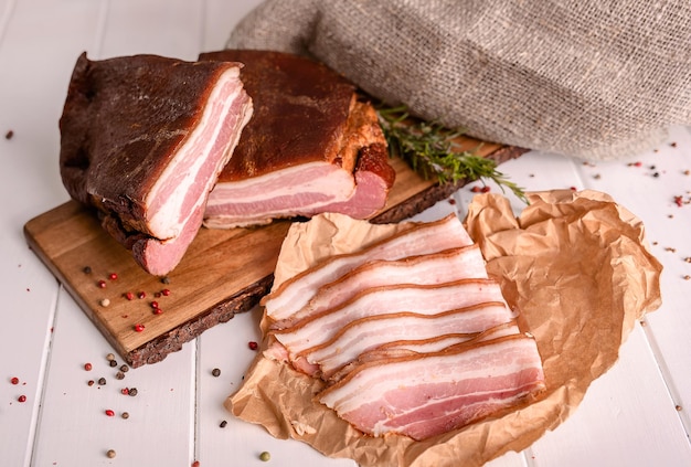 Smoked bacon sliced on a wooden cutting board Closeup selective focus