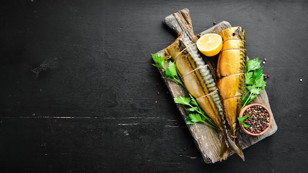 Smoked fish On a black wooden background Top view Free space for your text