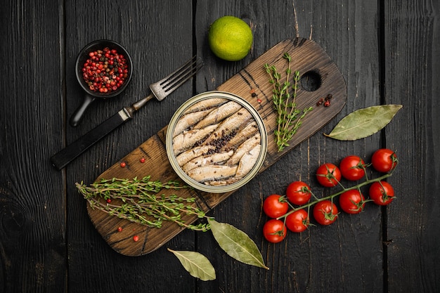 Smoked fish with olive oil set, on black wooden table background, top view flat lay