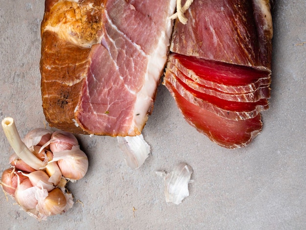 Smoked ham and jerky on table with garlic Natural product from organic farm produced by traditional methods