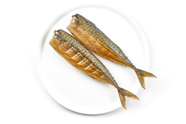 Smoked mackerel in a white plate on a white background Closeup selective focus