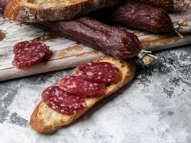 Smoked sausage sandwich on gray concrete background.