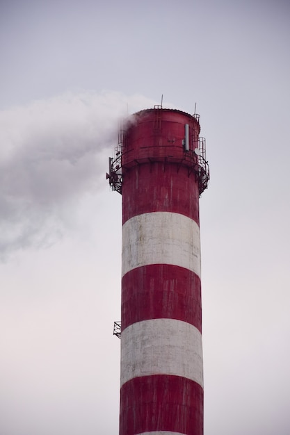 Smoking chimney of a factory or factory on the background of the sky