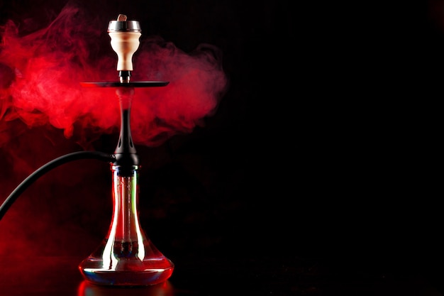 Smoking hookah on black background with color fog copy space