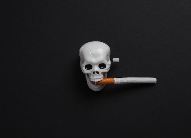 Photo smoking kills harm of nicotine skeleton skull with a cigarette on a black background