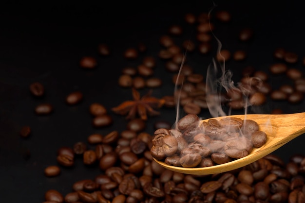 Smoky coffee beans on wood spoon coffee beans background