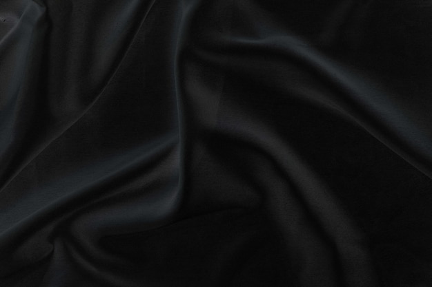 Smooth elegant black silk fabric or satin luxury cloth texture for abstract background