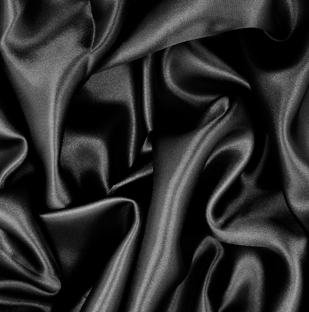 Smooth elegant black silk or satin texture as abstract background Luxurious background design