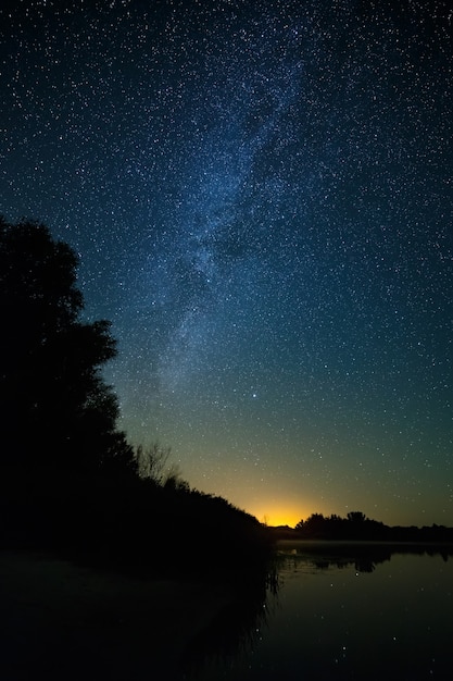 Photo smooth surface of the lake on a background the starry sky