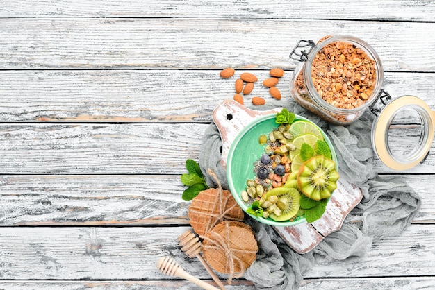 Smoothie bowl with green spirulina, kiwi, mint and pumpkin seeds. Breakfast. Top view. Free space for your text.