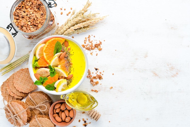 Smoothie bowl with orange banana lemon and almonds Breakfast Top view Free space for your text