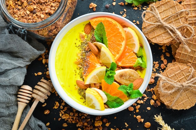 Smoothie bowl with orange banana lemon and almonds Breakfast Top view Free space for your text