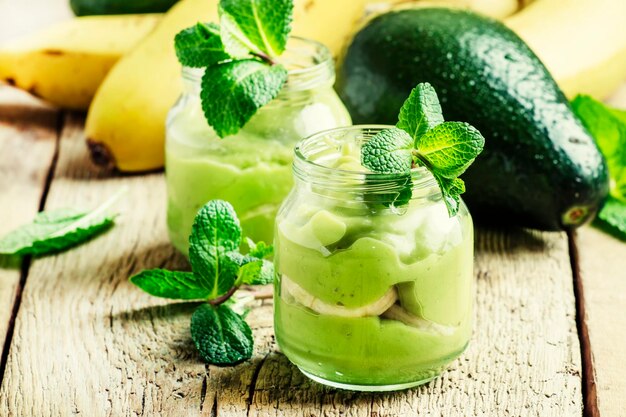 Smoothie from banana and avocado in small jars selective focus