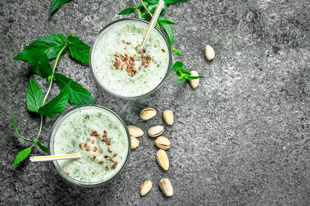 Smoothies with mint, pistachio and coconut milk. On rustic background.