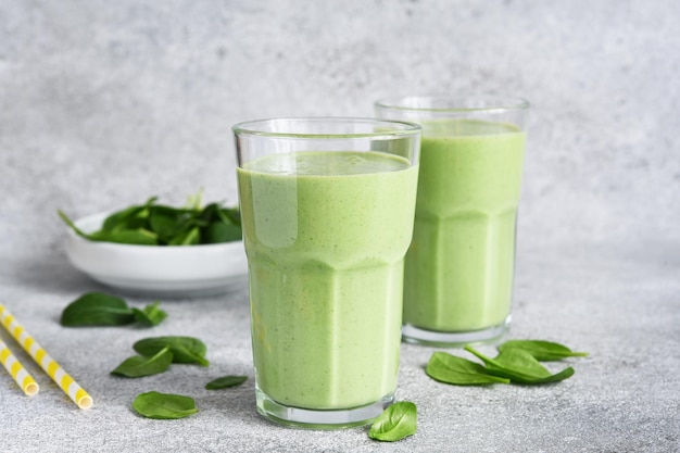 Smoothies with spinach and yogurt on a concrete stone background