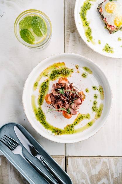 Smorrebrods Danish open sandwich with salmon egg roast beef sweet onions avocado and cilantro sauce