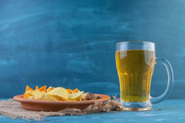 Snack plate and beer mug , on the blue background.