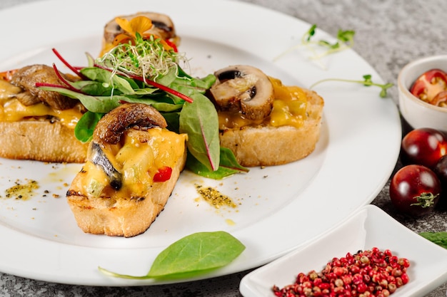 Snack of toasted bread with melted cheese and mushrooms on concrete background