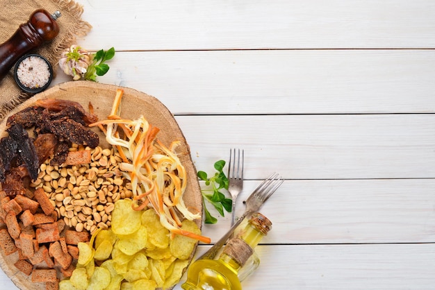 Snacks to beer. Chips, salted nuts, dried fish meat. On the old background. free copying space.