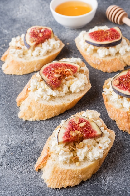 Snacks bruschetta with cottage cheese, walnut and honey and figs