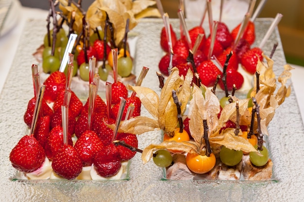 Snacks from fruit kiwi, pear, raspberry, strawberry and grapes for events and parties on small wooden sticks