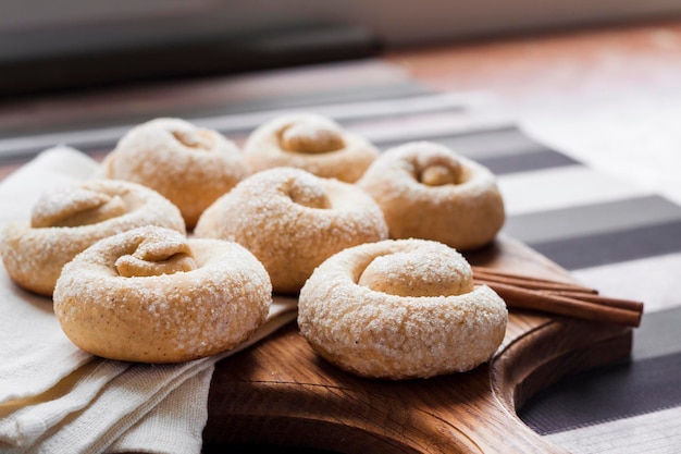 Snail sugar cookies with cinnamon on wooden board